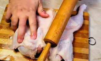 Turn the chicken over and beat it well with a rolling pin.