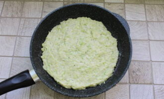 After heating a frying pan with vegetable oil, distribute the pizza base, leveling it with a spatula.