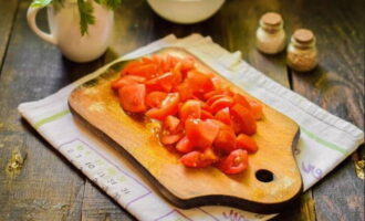 Basuh dan keringkan tomato. Potong mereka menjadi kiub yang sama seperti terung.