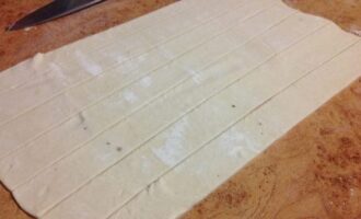 Roll out the puff pastry into a layer and cut into strips about two centimeters thick.