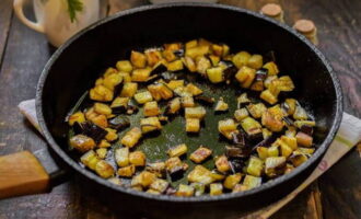 Verhit twee eetlepels plantaardige olie in een koekenpan en bak de aubergines op middelhoog vuur goudbruin.