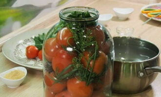 We continue filling the container up to the shoulders, placing the remaining greens on top.