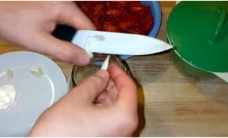 Place garlic cut into slices at the bottom of the jars.