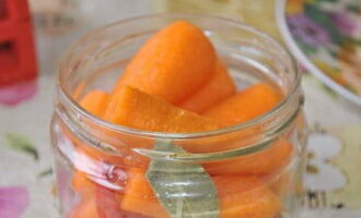 We clean the pre-washed carrots. Place the root vegetables in sterilized jars.