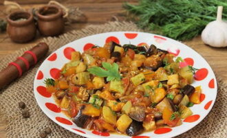 Grönsaksgryta från zucchini, aubergine, paprika och tomater i en stekpanna är klar. Kombinera med aromatiska örter och njut!