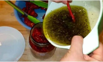 Vierta completamente la mezcla de aceite preparada sobre los tomates secados al sol. 