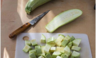 ¿Cómo cocinar deliciosamente calabacines en una olla de cocción lenta? Lavamos y pelamos las verduras, cortamos el calabacín en dados medianos.