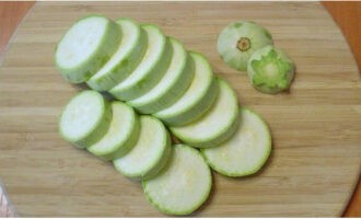 Tagliamo le code delle zucchine e le tagliamo ad anelli di medio spessore, aggiungendo sale.