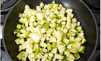 Skyl zucchinien med vand, skåret i tern og smid en tredjedel i en stegepande med vegetabilsk olie. 