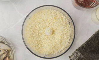 Rinse round rice several times with cold water, remove excess moisture with a napkin and grind the cereal with a food processor or blender into a homogeneous mass.