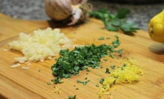 Without wasting time, peel the garlic and finely chop it. Wash the lemon and remove the zest. Rinse the parsley thoroughly.