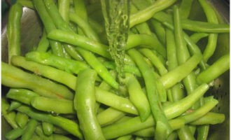 Coloca los frijoles en un colador. Lo lavamos con agua y vinagre. Esto ayudará a mantener el color verde vibrante de los frijoles.