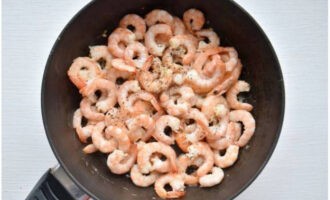 Add shrimp to garlic. Fry for about three minutes and sprinkle with a mixture of dried herbs and ground black pepper.