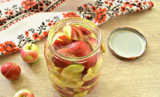 Place apple slices in sterilized jars, pour boiling water, cover with lids and leave for 20 minutes.