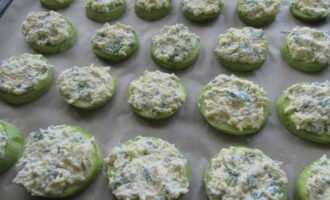 Place the zucchini circles on a baking sheet lined with parchment. Cover them with cheese mixture.