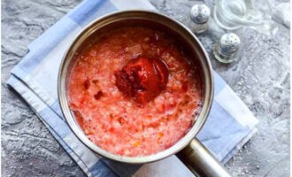 Vierta la mezcla de tomate y pimiento en una cacerola, agregue la pasta de tomate y el aceite vegetal; hierva y cocine a fuego lento hasta que espese (aproximadamente 50 minutos).