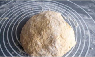 Knead the dough with your hands on a work surface dusted with flour. Cover the lump of dough with a napkin and leave it alone for 15 minutes.