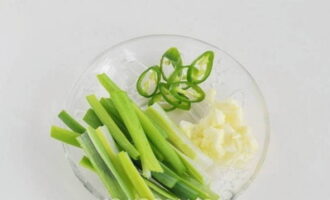 Cut the garlic cloves, chili peppers and green onions into strips.