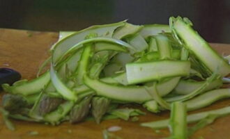 Was de aspergekiemen, snij de harde uiteinden eraf en kook ze 3 minuten in kokend water. Breng ze daarna over naar koud water, zodat ze hun felgroene kleur niet verliezen. Snijd de asperges met een dunschiller in dunne reepjes. Snijd de toppen af.