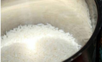 Rice with egg is prepared quickly and easily. After studying the recommendations on the pack of rice, carefully wash off the starch, rinsing the rice until the water runs clear.