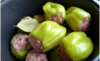 Place all the stuffed peppers in a stewing pan and add bay leaf with allspice. Pour the prepared tomato sauce over them and simmer over low heat for 40 minutes from the start of the boil. Then turn off the heat and let the dish sit under the lid for another 20 minutes.