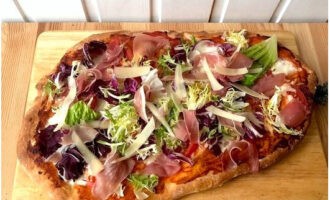 We take the treat out of the oven. We complement it with salad mix, prosciutto and slices of Parmesan cheese.