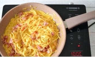 Après avoir égoutté les spaghettis, placez-les dans une poêle chaude. Versez la sauce et mélangez bien. Ajoutez le bacon frit et remuez à nouveau. En remuant, chauffez pendant une minute.