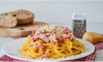 Répartir les pâtes carbonara dans les assiettes et saupoudrer de parmesan. Bon appétit!