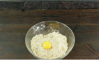 Grind the mass. Separate the egg into white and yolk. Add the yolk to the crumbs.