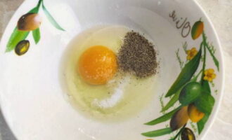 Break a raw egg into a separate bowl, add salt and black pepper and beat a little with a whisk.