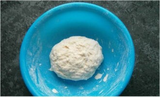 Pour water here and knead a homogeneous dough. Cover with cling film and remove for 30 minutes.