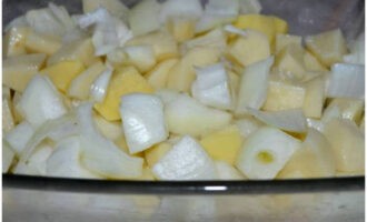 Before starting cooking, peel and rinse the potatoes and onions. Chop vegetables coarsely.Grease a glass baking tray with a little vegetable oil, lay out the chopped vegetables, sprinkle them with salt, mix and spread in an even layer.