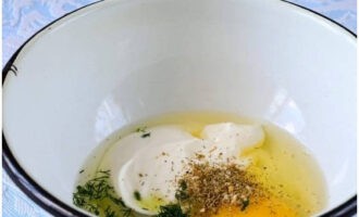 In a deep bowl, combine sour cream, chicken egg, soda, salt, spices and chopped dill.