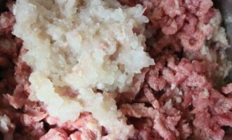 Nel frattempo passare una cipolla e la polpa di carne attraverso la griglia del tritacarne.