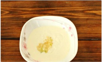 In a bowl, mix the ingredients for the sauce: sour cream and peeled garlic cloves passed through a press.