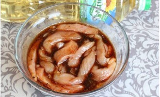 In a tall bowl, combine vegetable oil, soy sauce, paprika, adjika and dry ginger. After thoroughly mixing, unload the sliced ​​poultry into it. Marinate for a quarter of an hour.