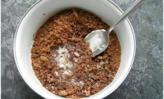 Butter schmelzen und abkühlen lassen. Die Sandkrümel in eine Schüssel geben und über die abgekühlte Butter gießen. Gut vermischen, bis eine glatte Masse entsteht.