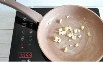 Melt the butter in a hot frying pan. Add chopped garlic.