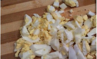 Boil a chicken egg, peel it and cut it into small pieces. Place in a bowl.