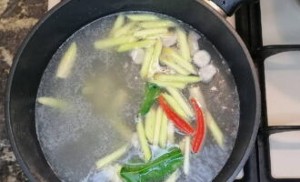 Ajouter tous les ingrédients préparés sauf les crevettes au bouillon bouillant.