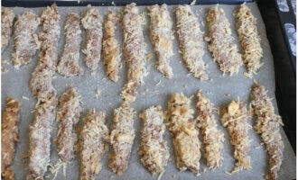 Line a baking tray with siliconized baking paper. Dip the marinated chicken fillet into beaten eggs and roll in breadcrumbs and cheese. Place the breaded pieces on a baking sheet.