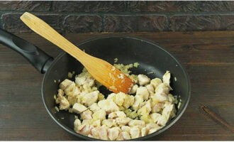 After rinsing the chicken fillet, blot it with napkins and cut it into cubes. Add to the onion and fry until white.