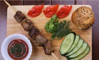 We complement the soft and juicy pork kebab with ketchup and herbs - take the first sample. Bon appetit!