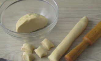 Divide the chilled dough in half, roll one part into a sausage and cut into pieces no more than one and a half centimeters wide.