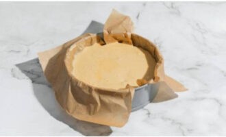 Linya ng parchment paper ang isang baking pan (22-24 cm) at lagyan ng mantikilya. Ilagay ang mga hiwa ng mansanas sa kuwarta at malumanay na ihalo gamit ang isang kutsara. Ibuhos ang minasa na masa sa molde.