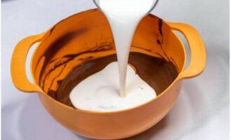 Pour cold heavy cream into the chocolate mixture. Mix the ingredients with quick movements.