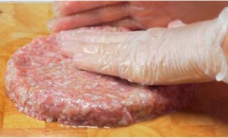 Grease the cutting board with vegetable oil so that the minced meat does not stick. Divide the entire mass into 2-3 equal parts. Then form flat cutlets with a diameter of 10-15 centimeters and a thickness of 1.2-1.5 centimeters on the board.