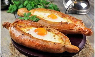 Servim khachapuri parfumat în stil Adjarian la masă fierbinte și savurând. Poftă bună! 