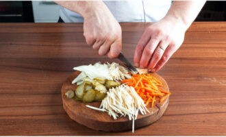 Peel onions, carrots, roots and cut into thin strips. Cut pickled cucumbers into thin slices.