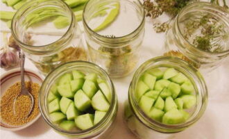 Place the sliced ​​cucumbers compactly and lengthwise into jars.